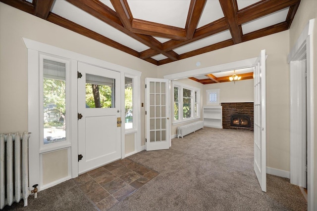 entryway featuring beamed ceiling, dark colored carpet, radiator, and coffered ceiling