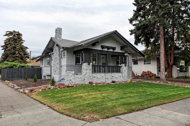 view of front of home featuring covered porch and a front yard