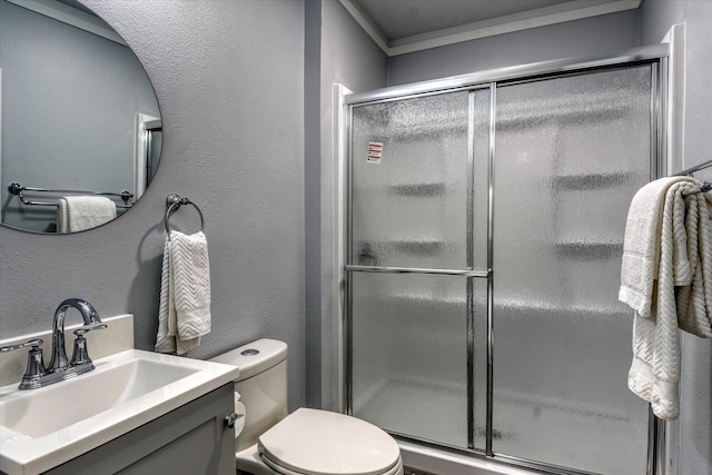 bathroom with vanity, ornamental molding, walk in shower, and toilet