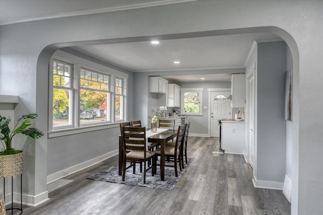 dining area with dark wood-type flooring and ornamental molding