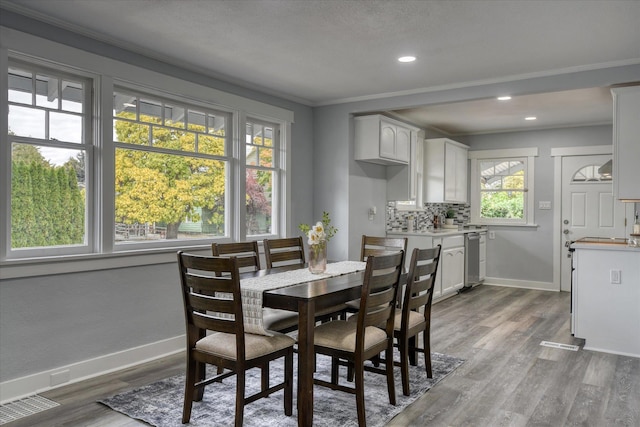 dining area featuring hardwood / wood-style floors and ornamental molding