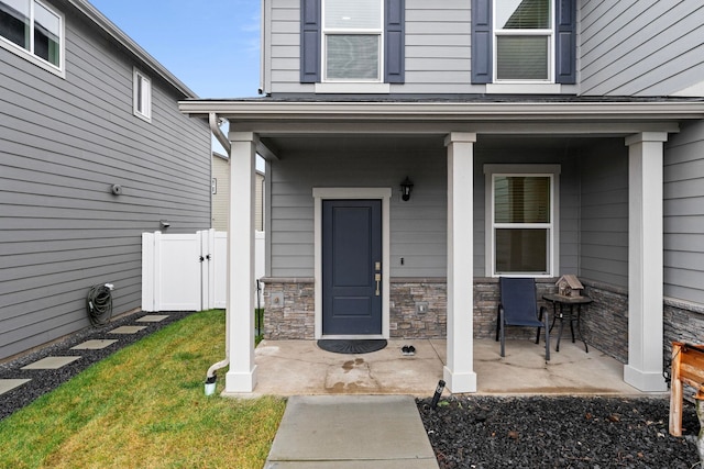 view of exterior entry with a lawn