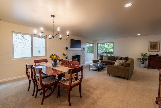 carpeted dining room featuring a fireplace and an inviting chandelier