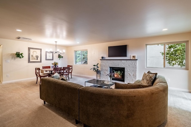 living room featuring a fireplace, light carpet, and an inviting chandelier