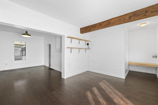 unfurnished room featuring dark hardwood / wood-style flooring and beam ceiling