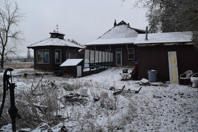 view of snow covered rear of property