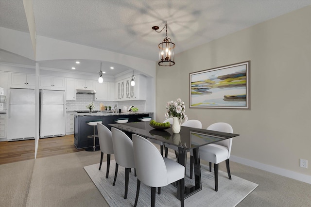 dining area featuring a textured ceiling and an inviting chandelier