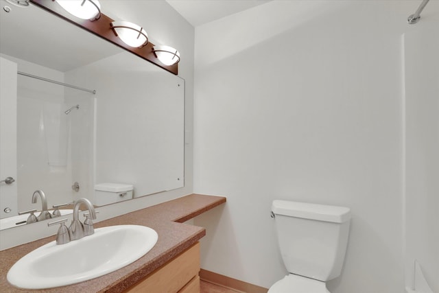 bathroom with a shower, vanity, and toilet