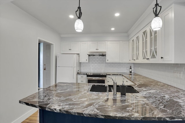 kitchen with dark stone counters, white cabinets, hanging light fixtures, and white refrigerator