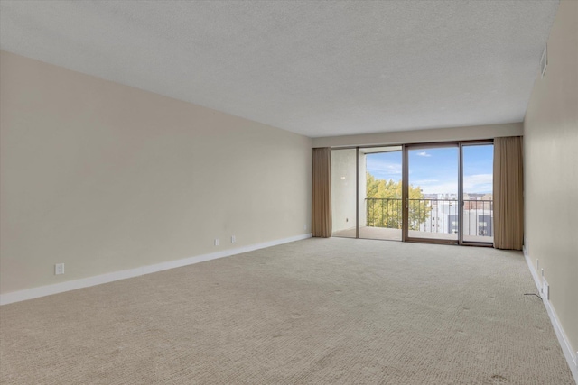 carpeted spare room with a textured ceiling