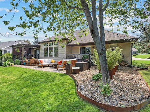 rear view of house featuring a lawn, an outdoor living space, and a patio area