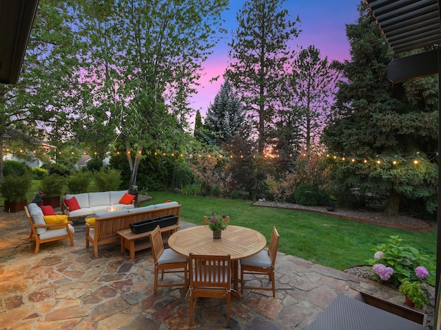 patio terrace at dusk featuring outdoor lounge area and a lawn