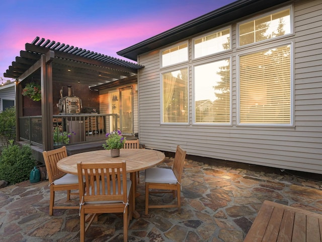 patio terrace at dusk featuring a pergola