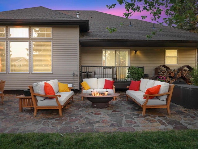 patio terrace at dusk featuring an outdoor living space with a fire pit