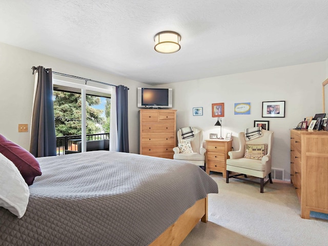 bedroom with access to exterior, a textured ceiling, and carpet floors