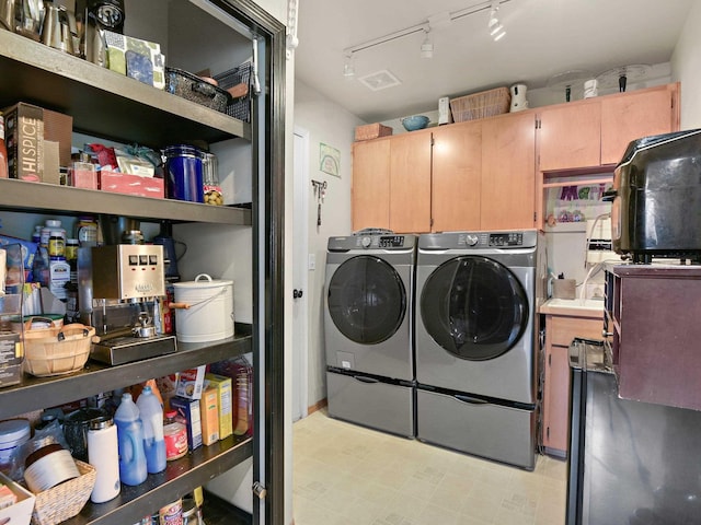 laundry area with washing machine and dryer and rail lighting