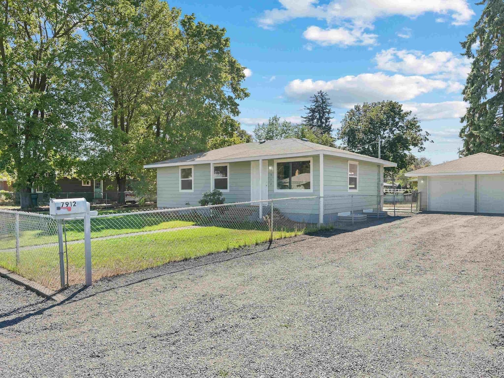 view of front facade with a front yard, a garage, and an outdoor structure