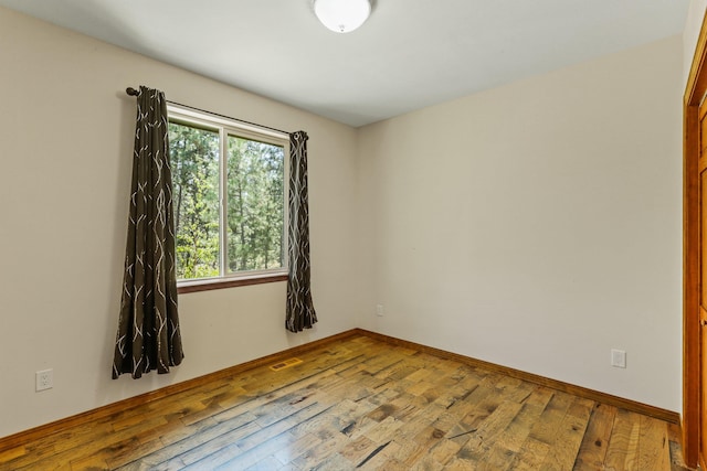 unfurnished room with hardwood / wood-style floors