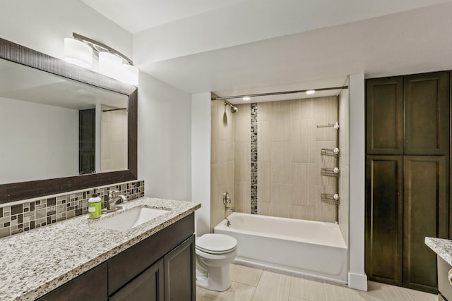 full bathroom featuring decorative backsplash, toilet, tiled shower / bath, and vanity