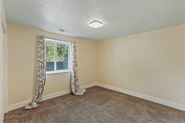 unfurnished room with carpet flooring and a textured ceiling