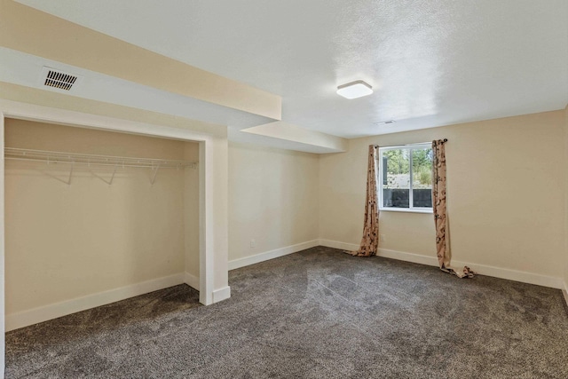 unfurnished bedroom with dark carpet and a closet