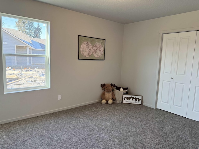 spare room featuring carpet and baseboards