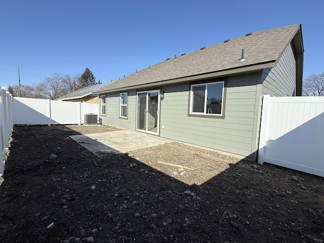 back of property with a patio area, cooling unit, a fenced backyard, and a shingled roof