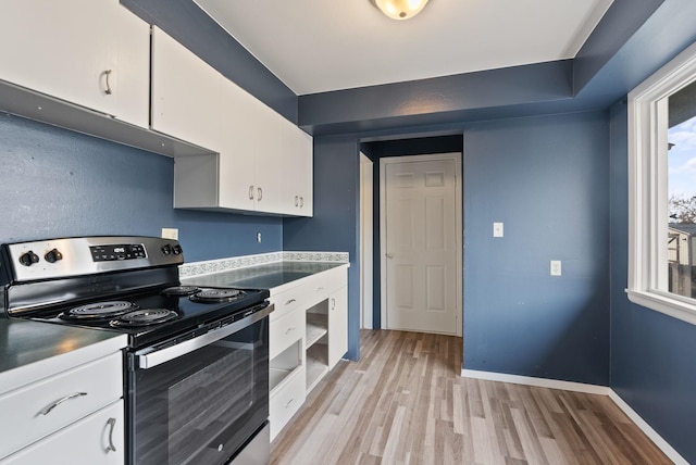 kitchen with white cabinets, light hardwood / wood-style floors, and stainless steel electric range oven