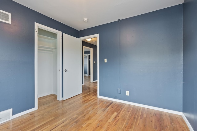 unfurnished bedroom with light hardwood / wood-style floors and a closet