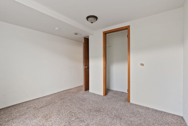 unfurnished bedroom with a closet and light colored carpet