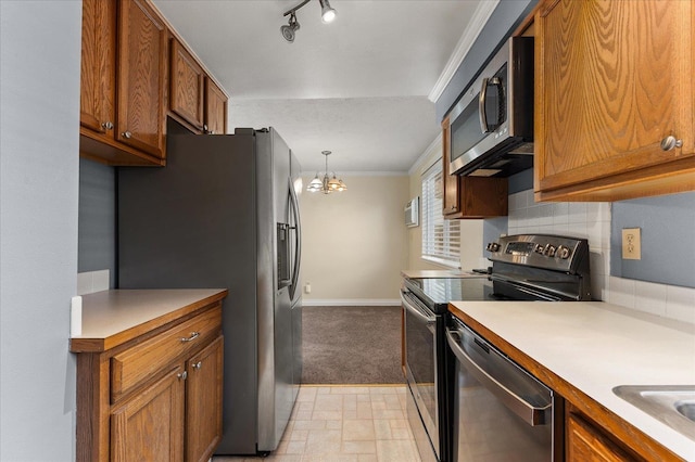 kitchen featuring backsplash, stainless steel appliances, crown molding, pendant lighting, and a notable chandelier