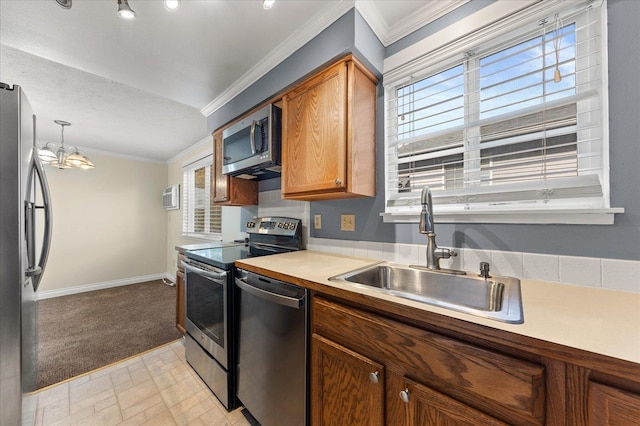 kitchen with sink, a chandelier, decorative light fixtures, appliances with stainless steel finishes, and ornamental molding