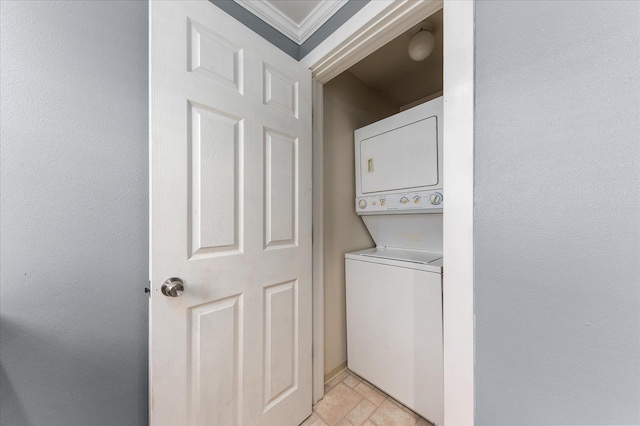 laundry area with stacked washer and dryer and ornamental molding