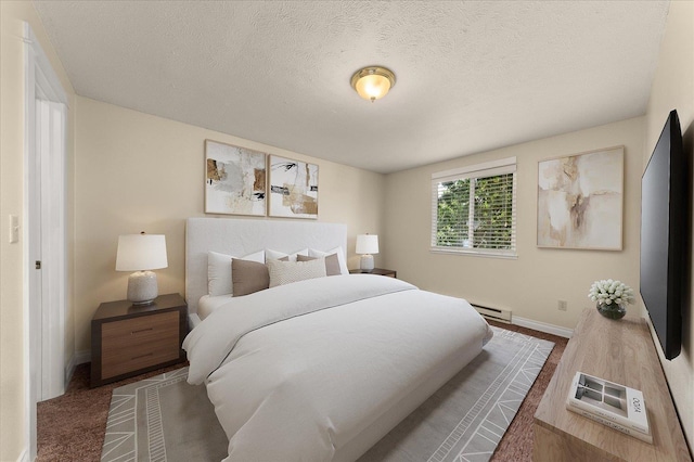 bedroom with baseboard heating, wood-type flooring, and a textured ceiling