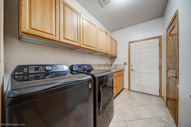 laundry area featuring washer and dryer, cabinets, and light tile patterned floors