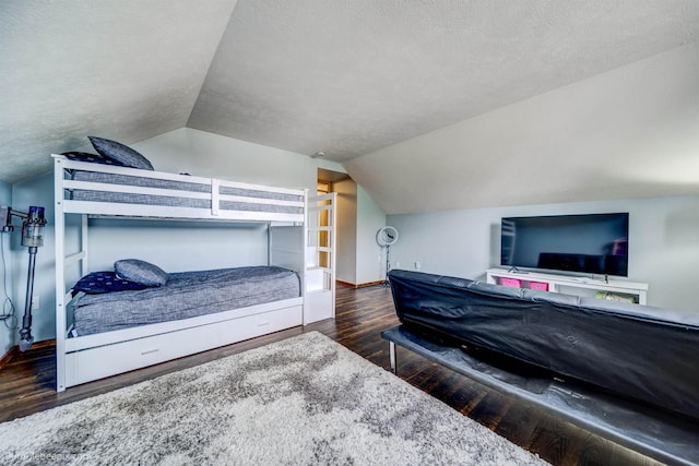 bedroom with a textured ceiling, dark hardwood / wood-style flooring, and lofted ceiling