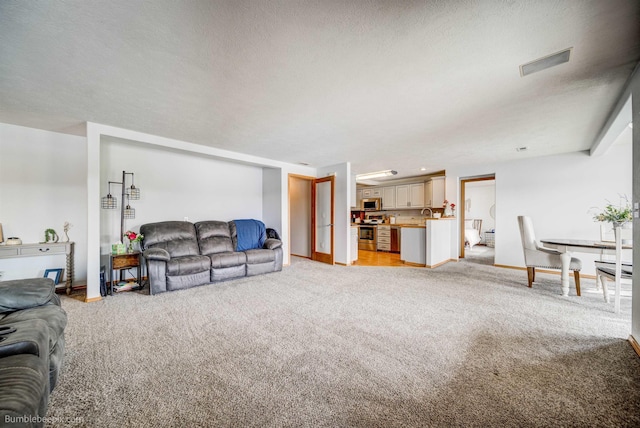 carpeted living room featuring a textured ceiling