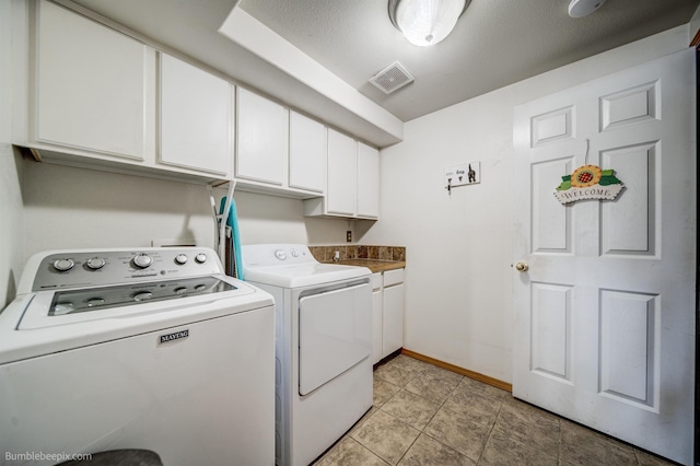 washroom featuring washer and dryer and cabinets