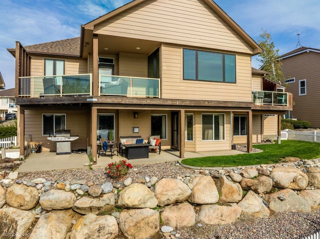 back of property featuring a balcony, an outdoor hangout area, and a patio