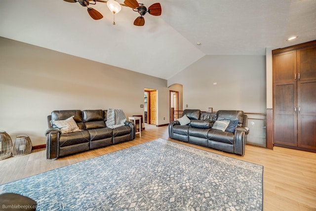 living room featuring ceiling fan, light wood-type flooring, and lofted ceiling