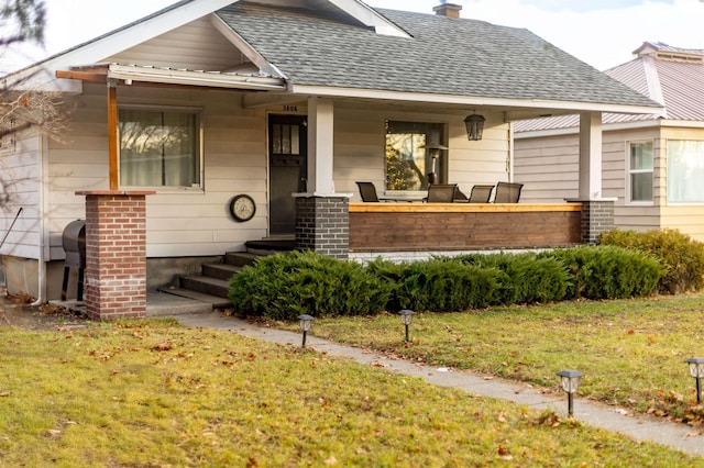 view of front of property with a front yard and a porch