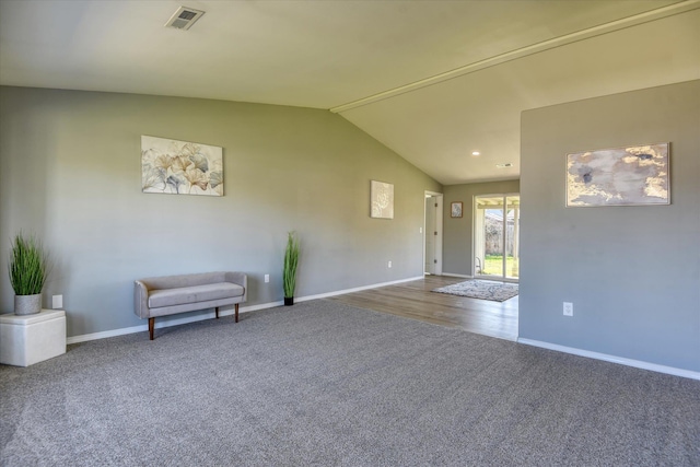 unfurnished room featuring carpet floors and vaulted ceiling