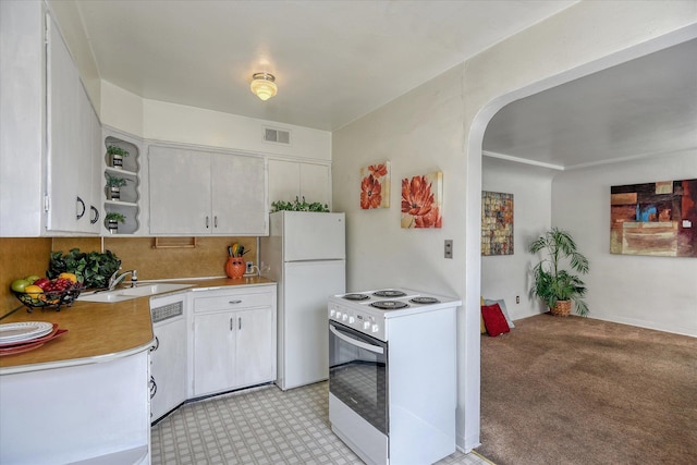 kitchen with light carpet, sink, white cabinets, and white appliances