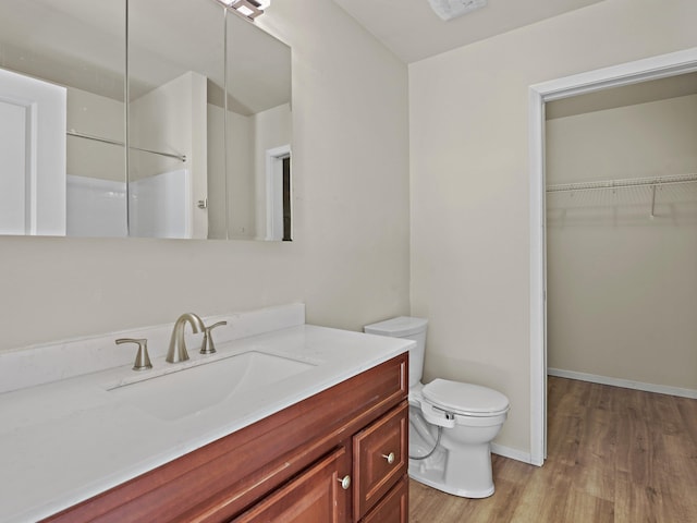 bathroom with toilet, vanity, and hardwood / wood-style flooring