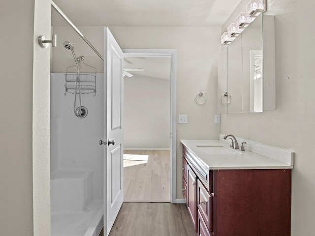 bathroom featuring a shower, vanity, hardwood / wood-style flooring, and ceiling fan