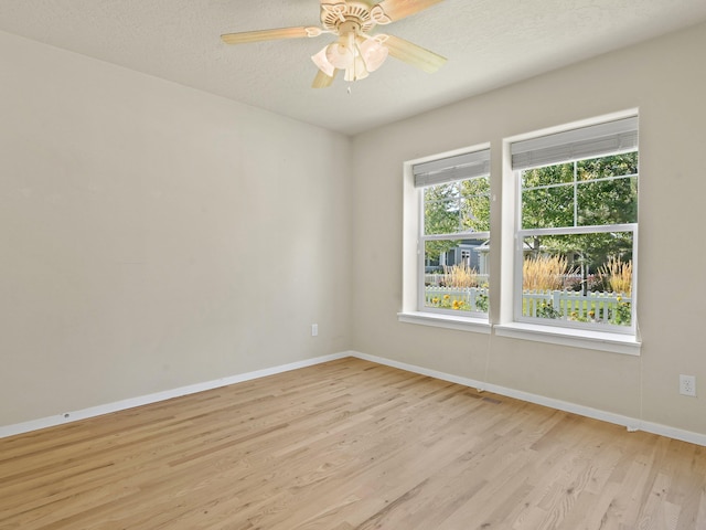 unfurnished room featuring a textured ceiling, light hardwood / wood-style floors, and ceiling fan