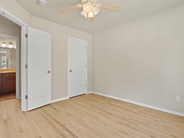 unfurnished bedroom with ensuite bathroom, light hardwood / wood-style flooring, and ceiling fan