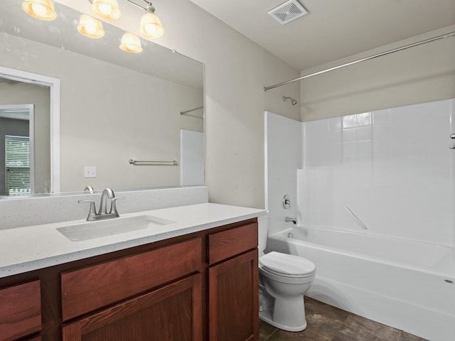 full bathroom featuring washtub / shower combination, vanity, and toilet