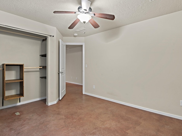 unfurnished bedroom featuring ceiling fan, concrete floors, a textured ceiling, and a closet