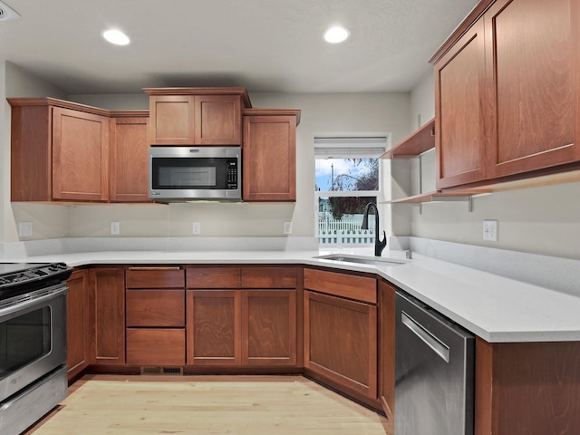 kitchen featuring sink, stainless steel appliances, and light hardwood / wood-style floors